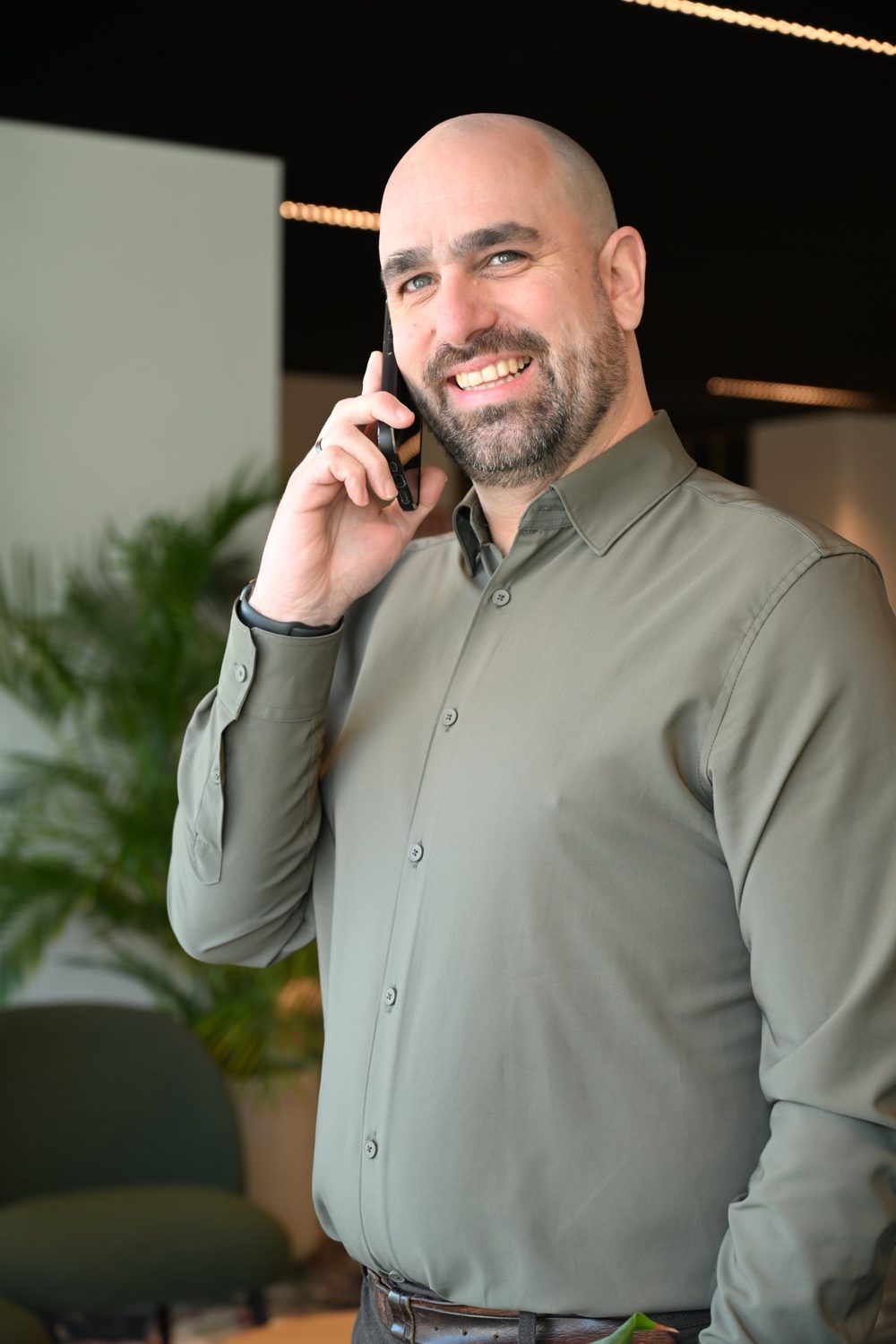 Tom Van Bueren aan de telefoon, lachend